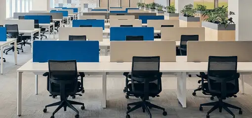 Modern open-plan office space featuring clean workstations, ergonomic chairs, and sanitized carpets provided by professional office cleaning services in Las Vegas, NV.