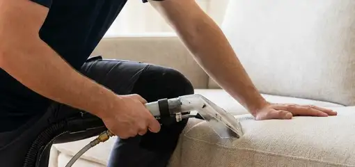 Professional upholstery cleaner deep-cleaning a fabric sofa with a handheld extraction tool, Las Vegas, NV.